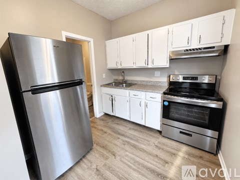 A kitchen with a stainless steel refrigerator, oven, and cabinets.