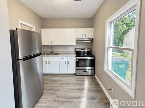 A kitchen with a refrigerator, cabinets, and a dishwasher.