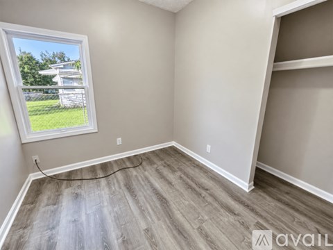 A room with a window and wooden flooring.