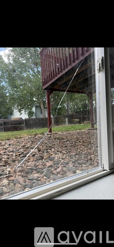 A window with a view of a red structure and a grassy area.