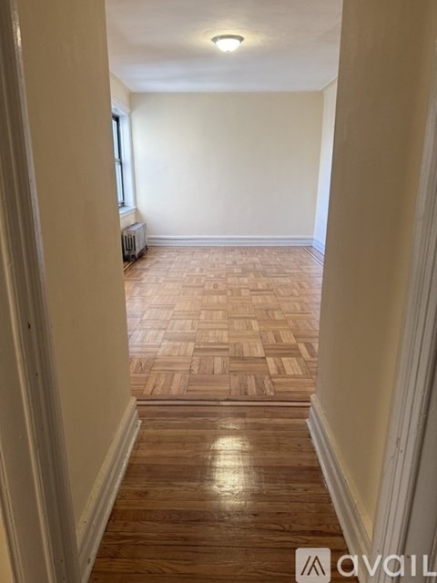A hallway with wooden floors and white walls.