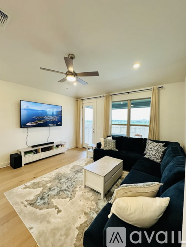 A living room with a blue couch and a flat screen TV mounted on the wall.