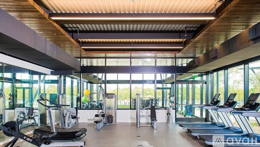 A gym with treadmills, elliptical machines, and other exercise equipment.
