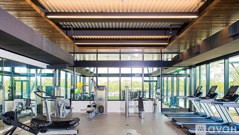 A gym with treadmills, elliptical machines, and other exercise equipment.