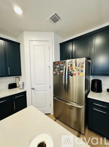 A kitchen with a refrigerator covered in magnets.