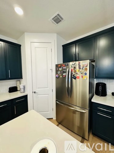 A kitchen with a refrigerator covered in magnets.