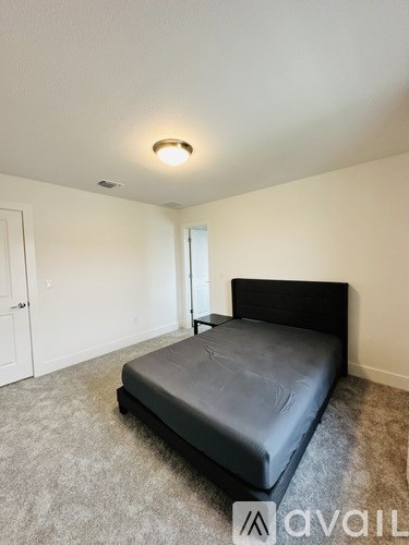 A bedroom with a bed and a carpeted floor.