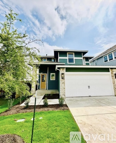 A house with a green front yard and a white garage door.