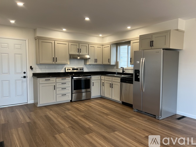 A kitchen with wooden floors and stainless steel appliances.