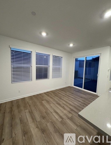 A room with wooden flooring and a sliding glass door.