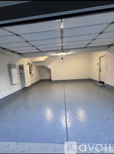 A spacious room with a grey floor and white walls.