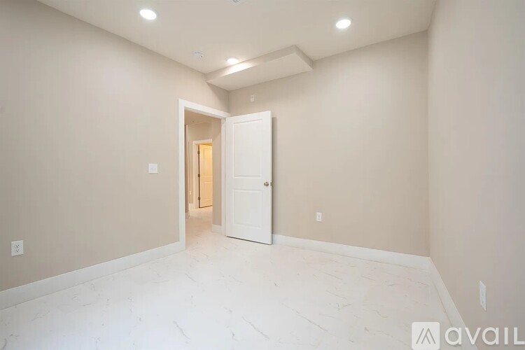 A room with a white door and a tiled floor.