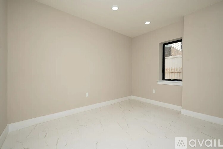 A room with a window and a wooden floor.