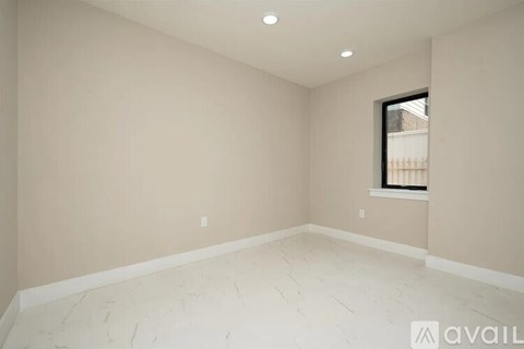 A room with a window and a wooden floor.