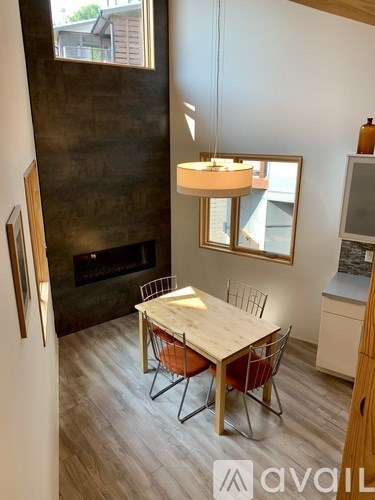 A modern dining room with a wooden table and chairs.