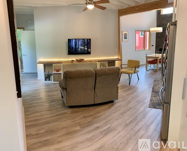 A living room with a couch, chair, and television.