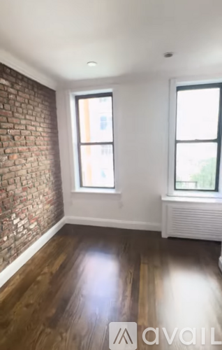 A room with a brick wall and wooden flooring.