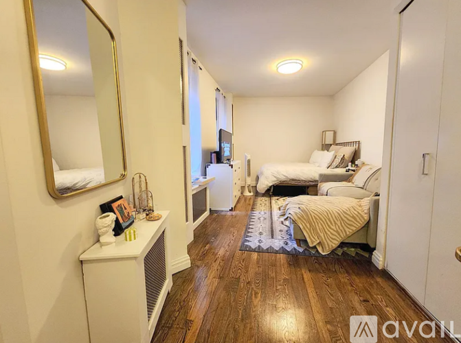 A bedroom with a bed, a dresser, and a mirror.