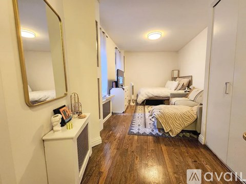 A bedroom with a bed, a dresser, and a mirror.