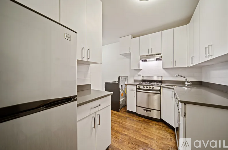 A kitchen with white cabinets and a stainless steel oven.