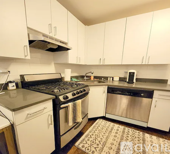 A kitchen with white cabinets and a black stove top oven.