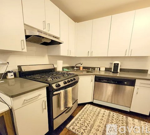 A kitchen with white cabinets and a black stove top oven.
