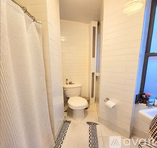A white toilet in a small bathroom with a shower curtain.