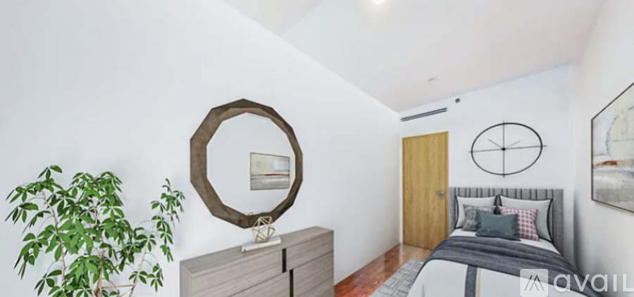 A bedroom with a bed, a mirror, and a plant.