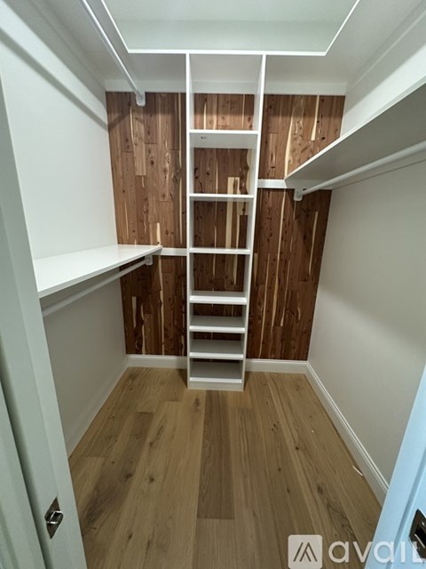 A small room with a wooden wall and a white ladder.