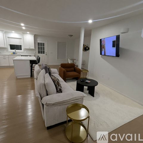 A living room with a couch, chair, and television.