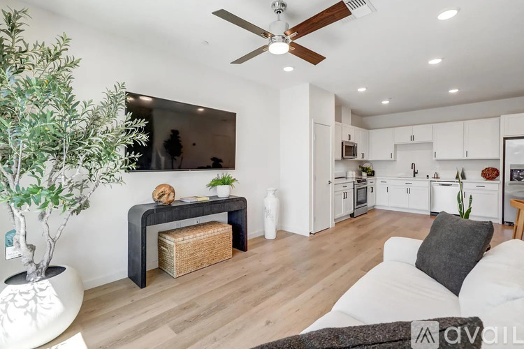 A living room with a white couch and a wooden floor.