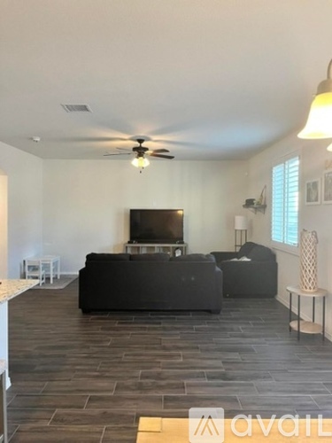 A living room with a black couch and a television.