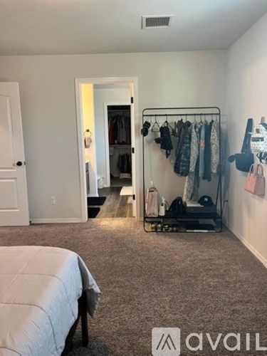 A bedroom with a bed, a closet, and a mirror.