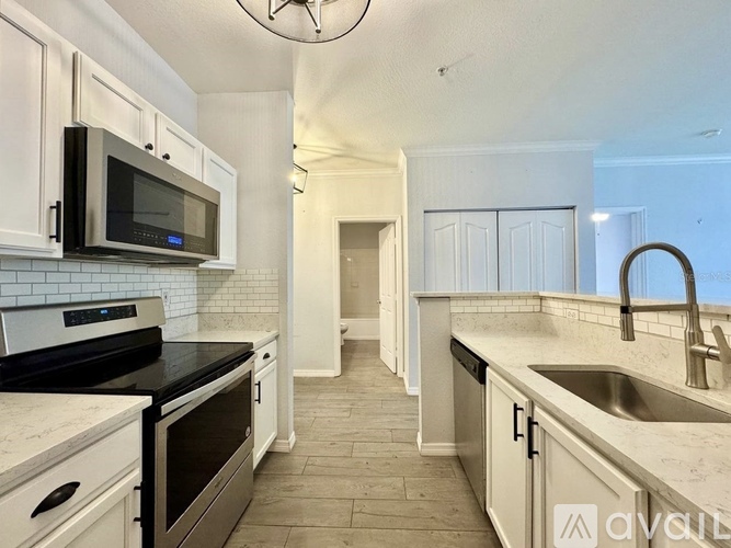 A kitchen with white cabinets and black appliances.