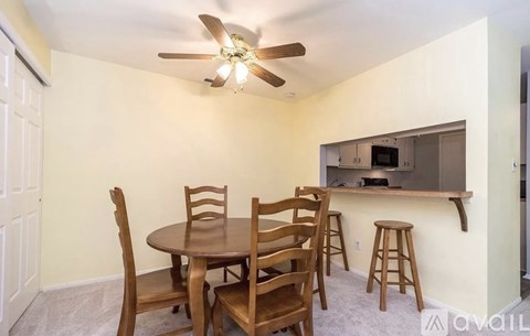 A dining room with a table and chairs.