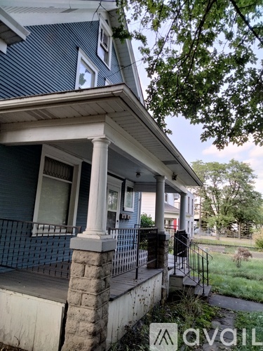 A house with a blue siding and a porch with a railing.