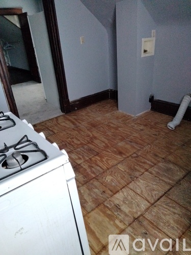 A room with a wood floor and a white stove.