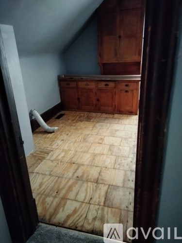 A room with wooden flooring and a cabinet.