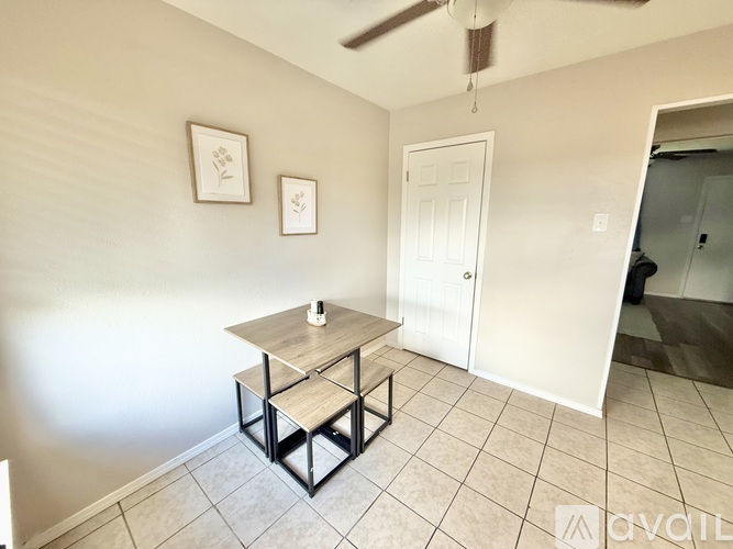 A table with a cup on it sits in a room with a white door.