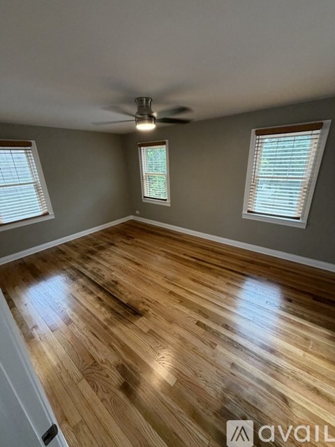A room with wooden flooring and a ceiling fan.