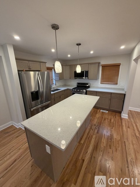 A kitchen with wooden floors and a central island.