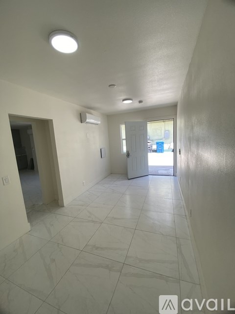 A long hallway with tiled floors and white walls.