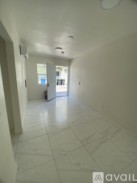 A long hallway with tiled floors and white walls.