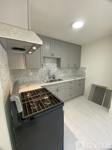 A kitchen with a black oven and white cabinets.