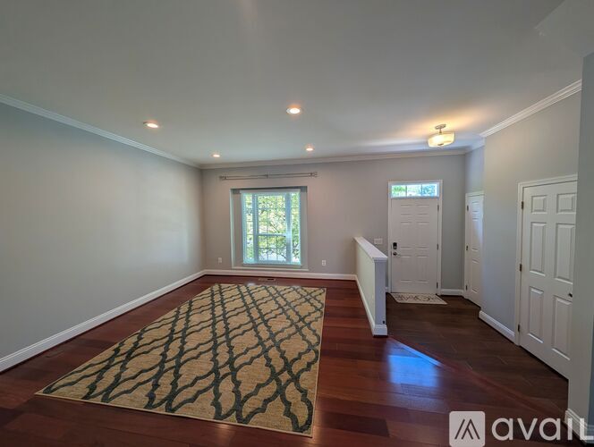 A room with a rug on the floor and a window letting in light.