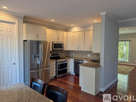 A kitchen with white cabinets and a granite countertop.