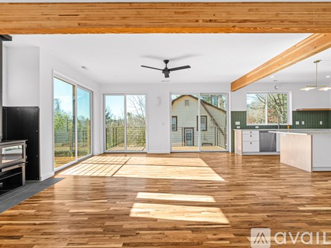 A spacious room with wooden floors and a ceiling fan.