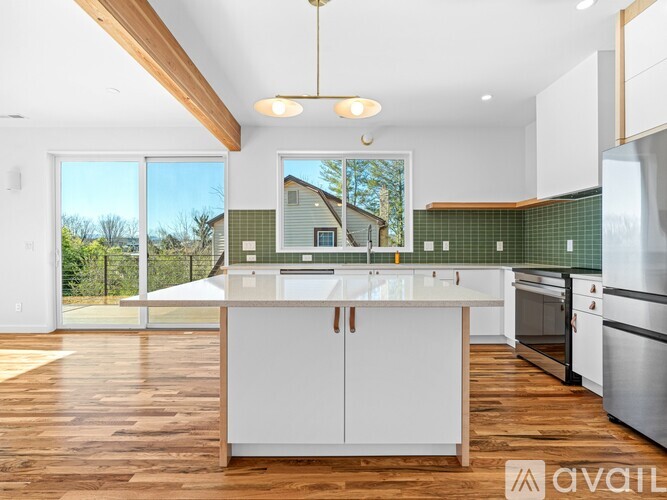 A modern kitchen with white cabinets and a wooden island.