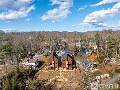 A bird's eye view of a large house surrounded by trees.