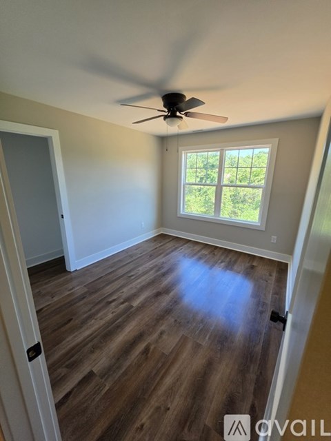 A room with a ceiling fan and a window.